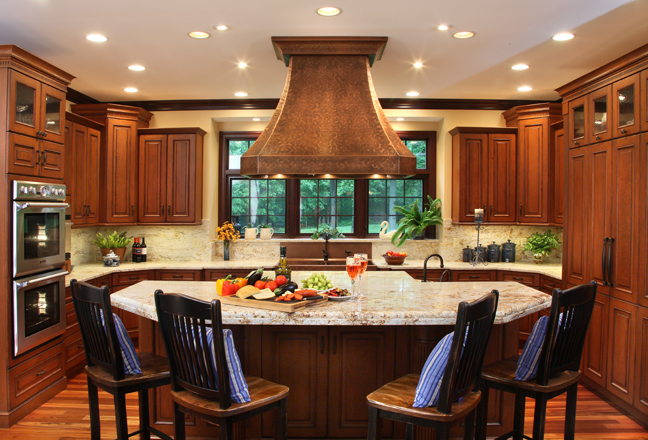 A copper Over Island hood draws the eye immediately to the island and creates a beautiful and functional focal point in the kitchen. 