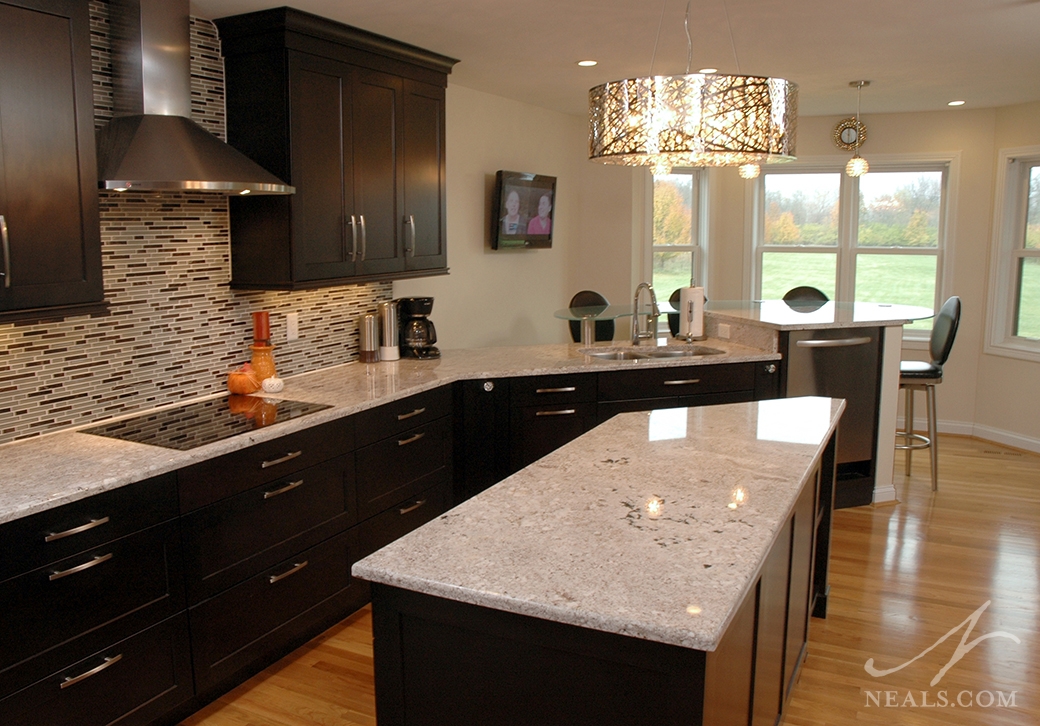 A custom light fixture hanging above the island in this kitchen is a great way to draw the eyes upwards, and brightens up the dark wood in the space.