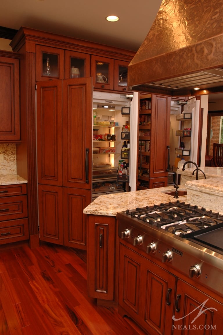 An expansive of cabinets conceals two refrigerators and a pull-out pantry cabinet.