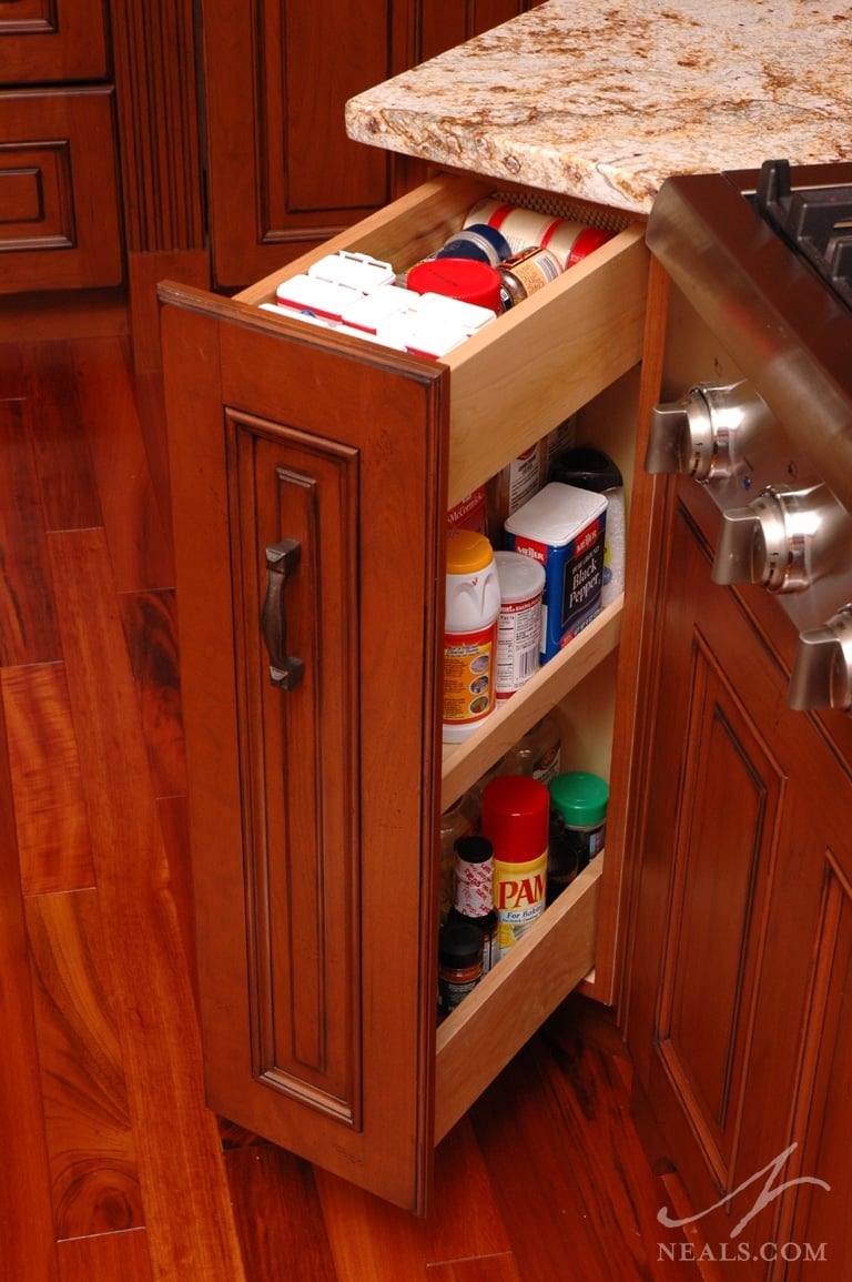 Spice cabinet tucked into the space next to the cooktop.