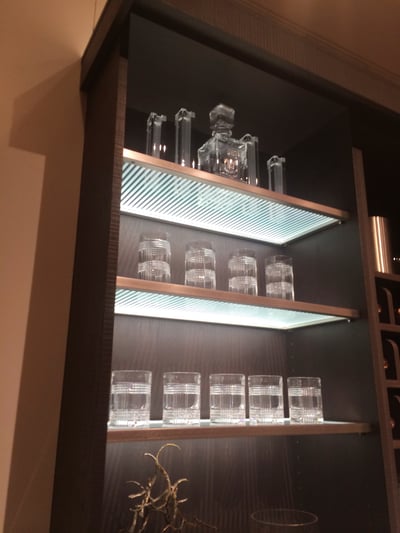 The cool green tint in these frosted glass shelves gives off a clean modern light for a wet bar.
