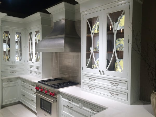 French Country dishes make a statement in these white cabinets with walnut interiors by Wood-Mode.