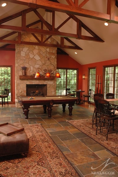 The cathedral ceiling in this rec-room addition is highlighted by the full-height fireplace surround and the exposed rafters.