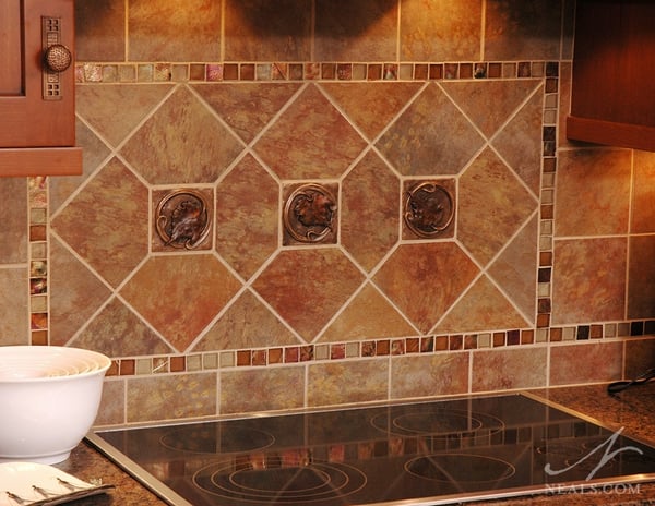 A mixture of natural stone tiles, artisan glass mosaic tiles, and accent tiles featuring a leaf design create an up-to-date take on the Craftsman backsplash.