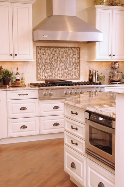In this kitchen, the drawer size dictated hardware type while reserving knobs for the cabinets above.