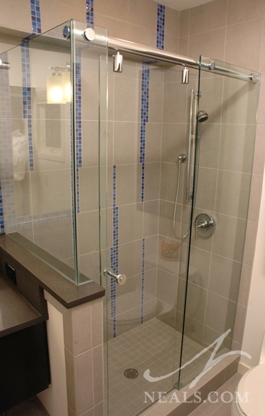 Playful blue glass mosaic tile creates a design feature in the otherwise neutral shower..
