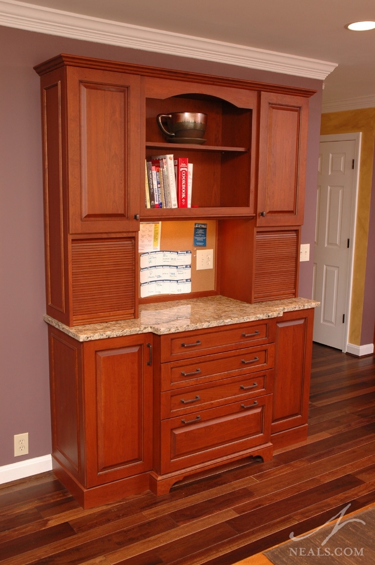 Between the living room and the main hallway, the communication center in this kitchen remodel is a great spot for the family calendar. With plenty of outlets, the counter doubles as a charging station.