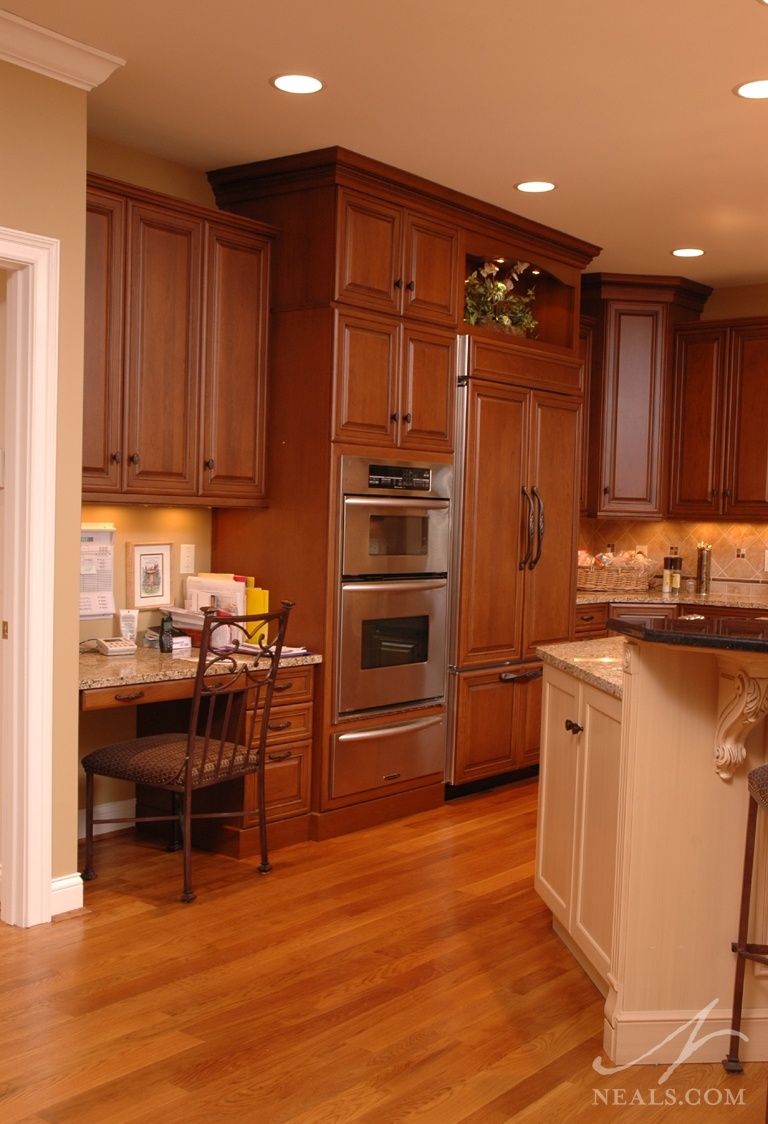 A desk on the end of this U-shaped kitchen provides a droping point for the family, but also makes sitting down to fill out papers, do homework, or write letters more convenient.