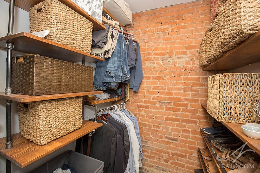 Baskets help keep this small walk-in closet clutter free and add style in this Newport project.