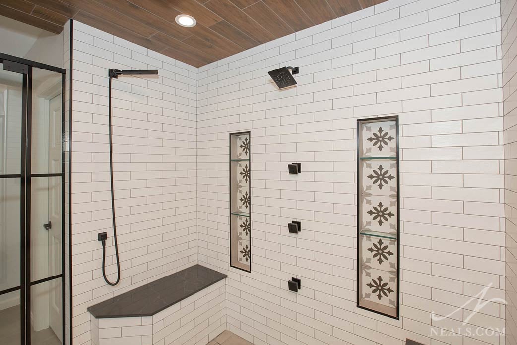 Shower interior with two wall niches and a variety of showerheads and body sprays