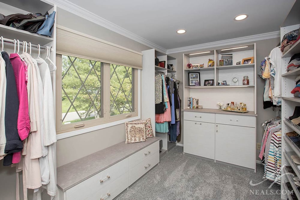 This Blue Ash dressing room features a variety of clothes storage options.