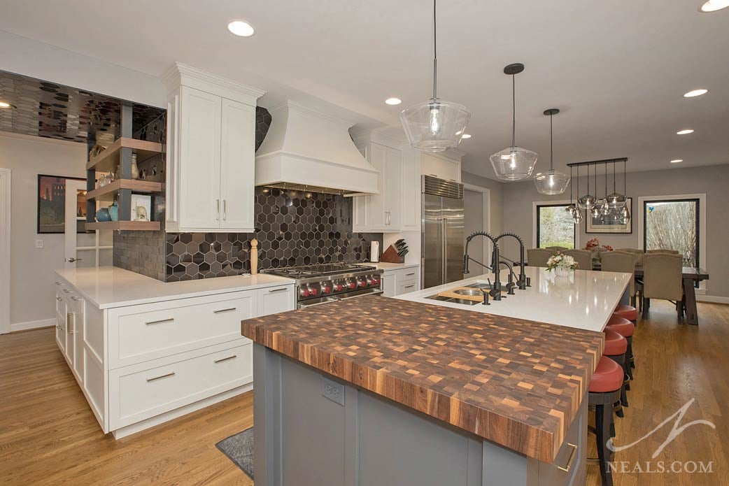 Kitchen with island and range showing the butcher block detail and bold black tile backsplash