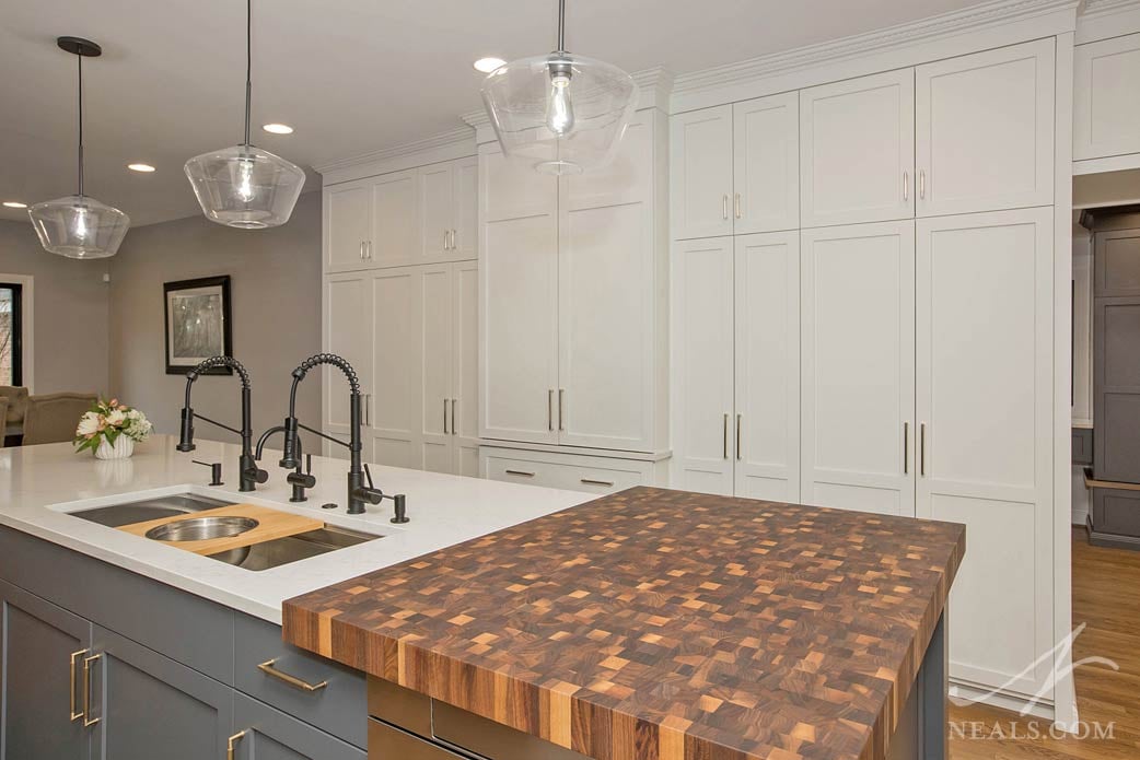 A large butcher block in the foreground and a long bank of tall cabinets in the background