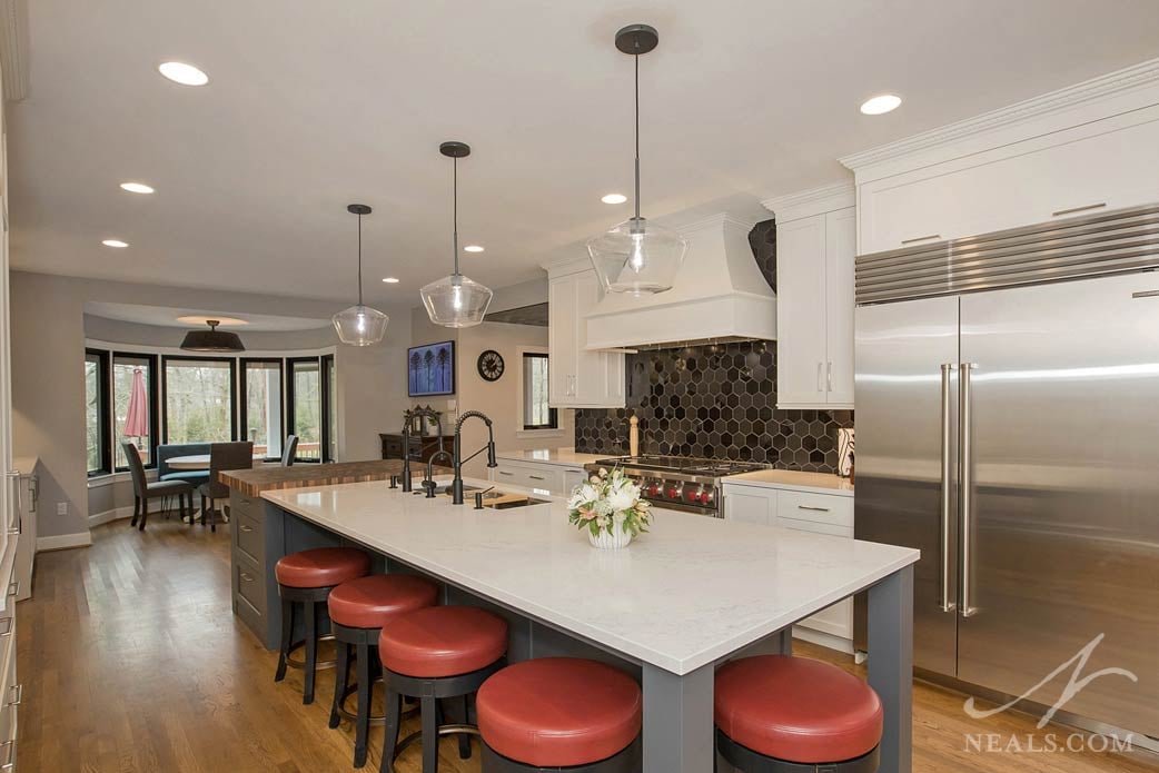 The long central kitchen island houses the sink and has seating space for 5