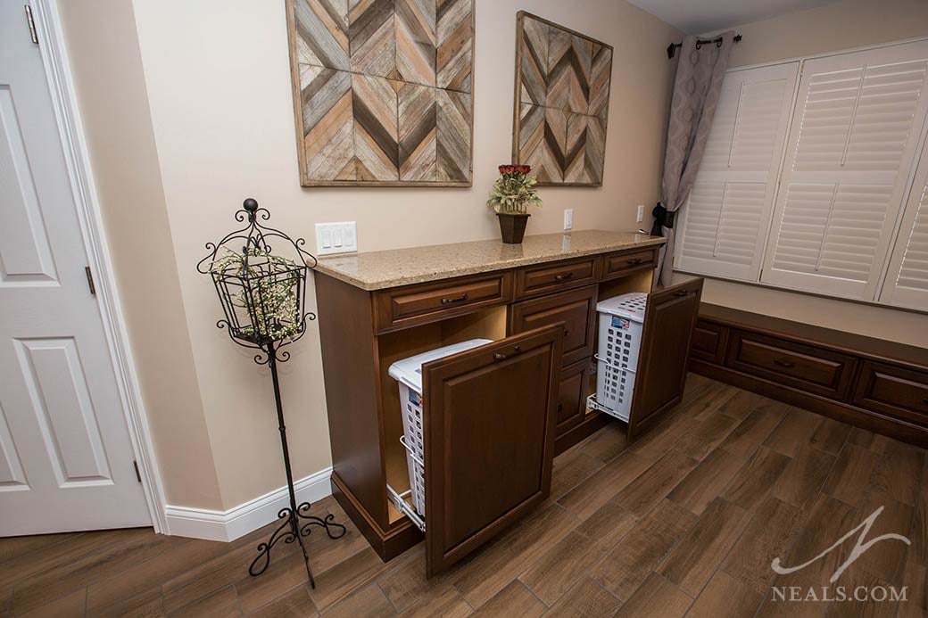 A storage cabinet across from the shower in this Maineville bathroom holds two clothes hampers.