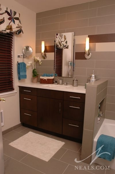 In this contemporary bathroom remodel, the vanity makes use of the space at the end of the tub.