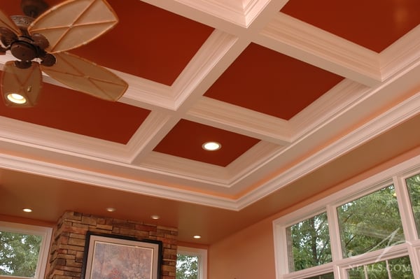 The deep and unexpected orange highlights the coffers in this sunroom room ceiling.