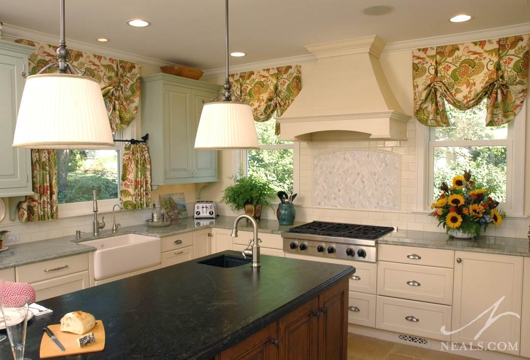 The island in this Glendale kitchen is topped with a striking dark Antolini soapstone that adds an eclectic tone to the cottage-style space.