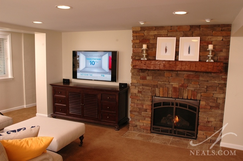 The fireplace in this basement sitting room shares the wall with the TV by taking up just one corner of the large niche space.