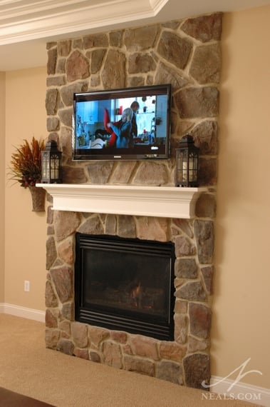 These two similar stone fireplaces are situated on a corner, facing the main space, providing the atmosphere of a fireplace without taking up a large footprint in their respective rooms. 