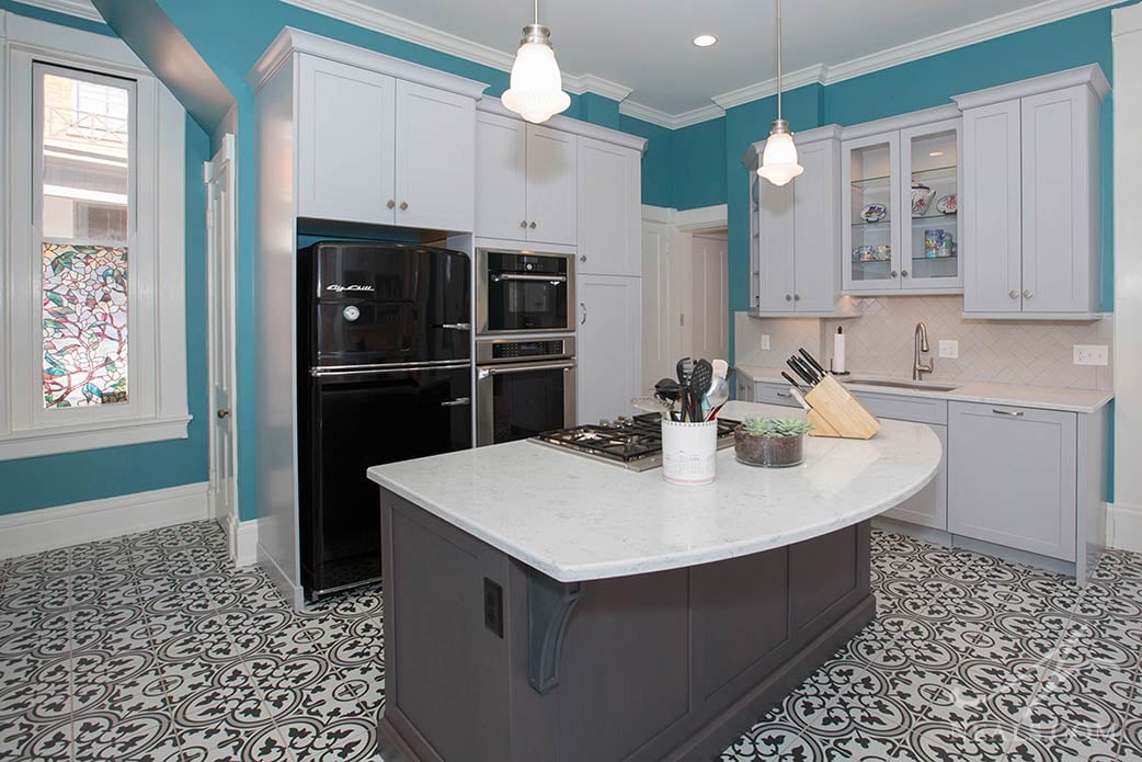 The bold black and white floral pattern of these floor tiles creates a fun and dramatic landscape in this Walnut Hills kitchen.