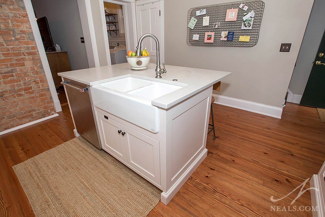 This small island in a Newport kitchen holds a sink, dishwasher and room for seating on the other side.