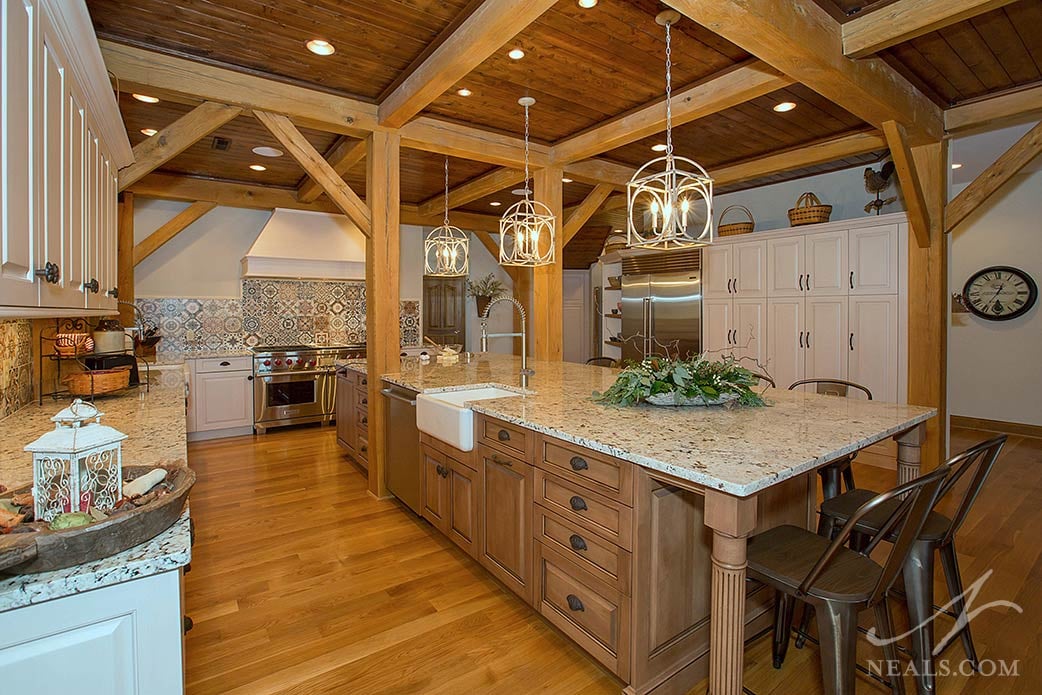A large island with naturally stained cabinetry plays on the idea of the old farmhouse table in this Middletown kitchen.