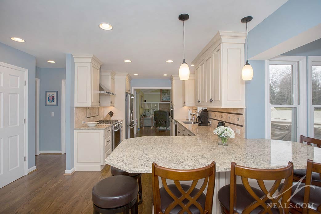 This peninsula in Montgomery, which acts like a kitchen table, is lit with two simple and classic glass pendant lights.