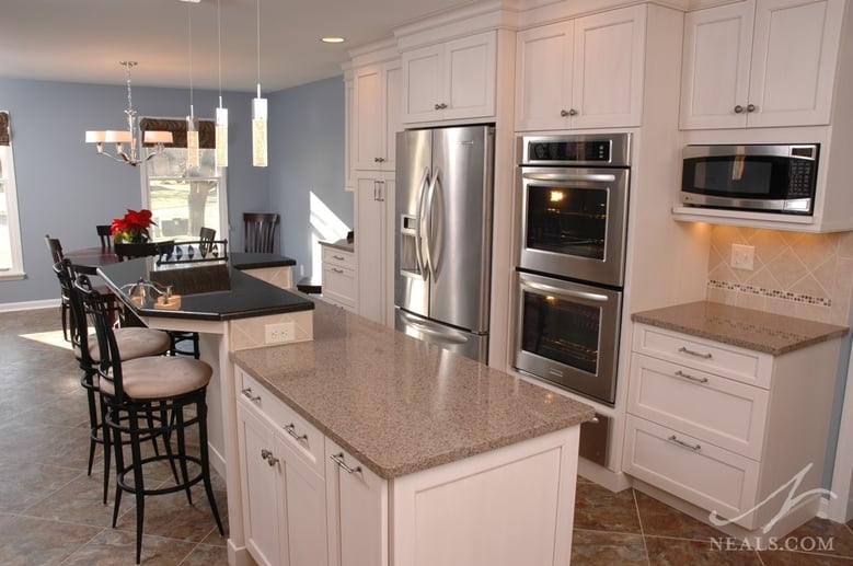 The working counter and eating counters are separated in this kitchen by both height and color.