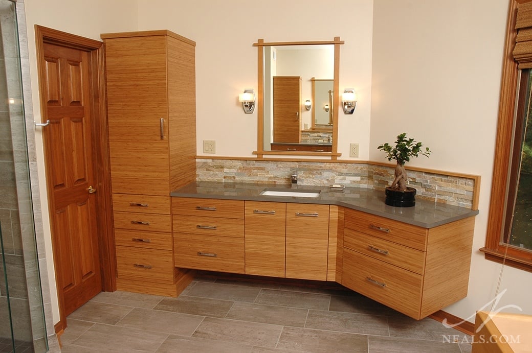 Bamboo veneer cabinetry, natural slate on the backsplash, polished nickel hardware, and ceramic tile flooring combine in this master bath to create a balanced, natural space.